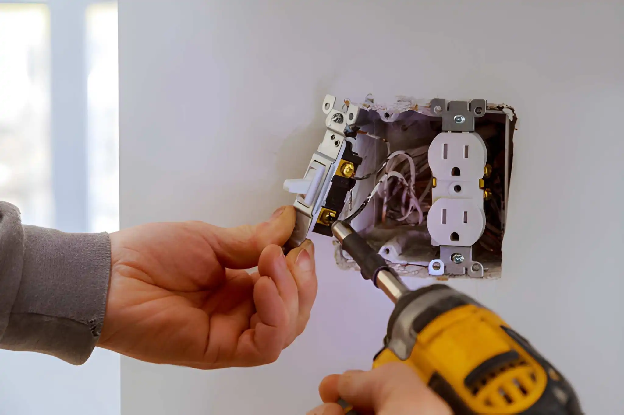 تركيب مفتاح ومقبس كهربائي داخل جدار شقة سكنية في الإمارات باحترافية